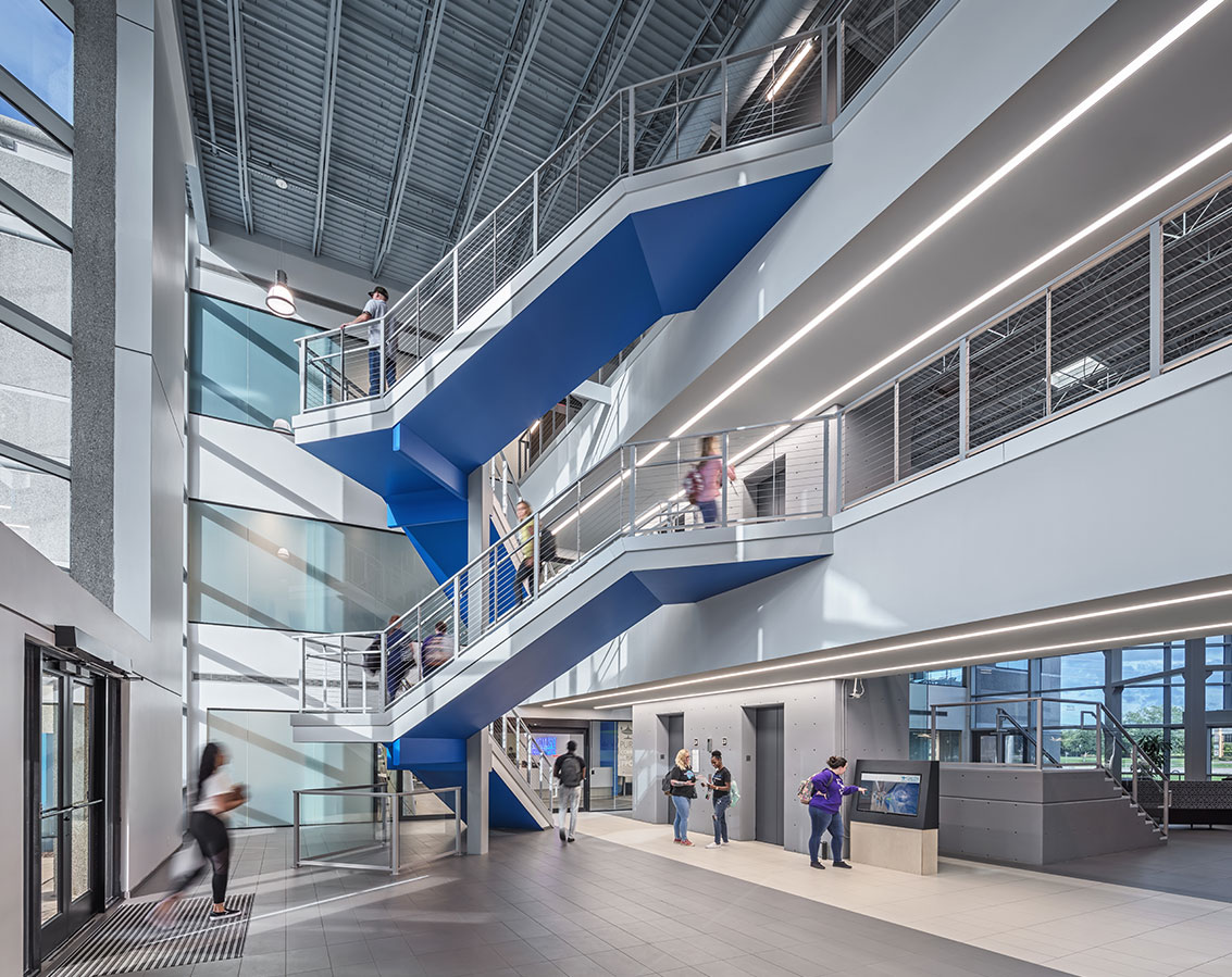 A staircase with blue accents connects multiple floors
