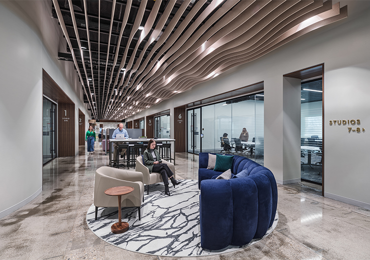 The central corridor offers lots of seating space for employees. Studios break off from the corridor, providing meeting and breakout room spaces.