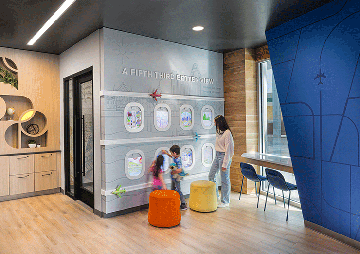 Mother and children enjoying interactive play at the CVG Fifth Third branch's kids corner.