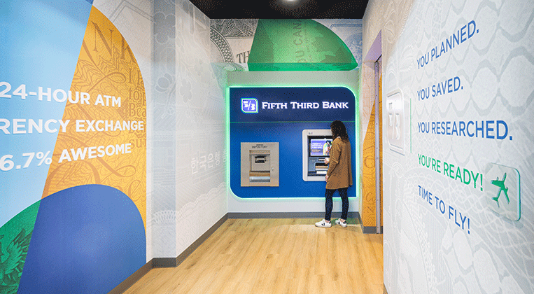 Customer using Fifth Third Bank's 24-hour international currency ATM at CVG branch