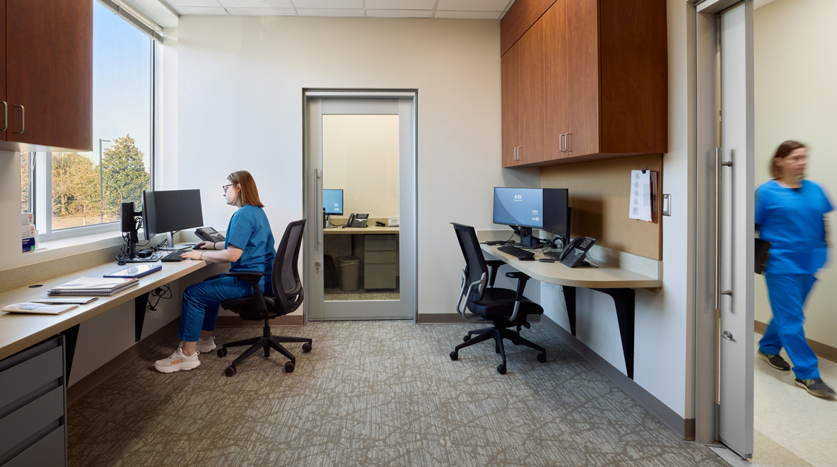 A provider charts on a computer inside a provider workroom