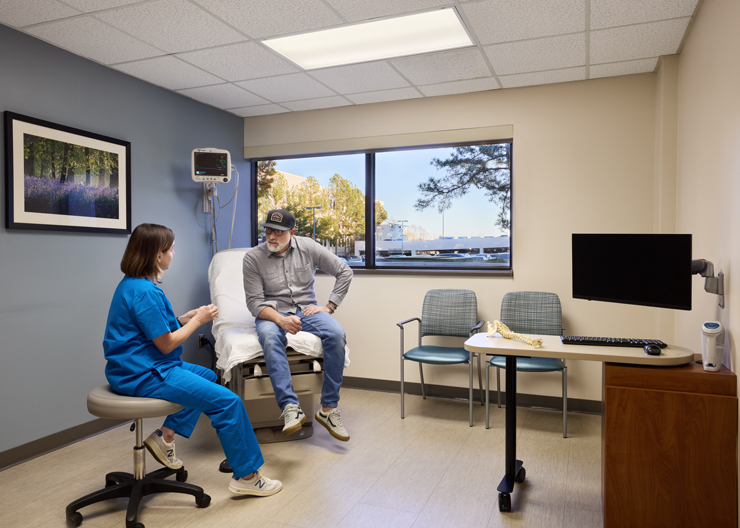 A patient and a provider discuss treatment in an exam room