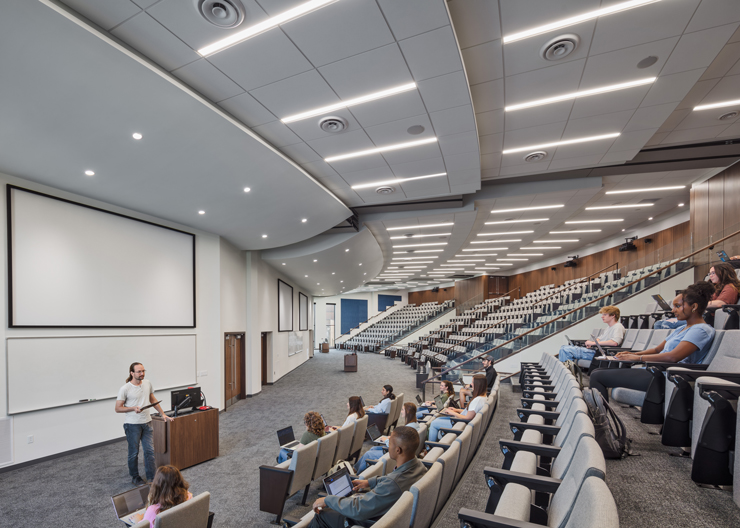 Students take a class in a large lecture hall