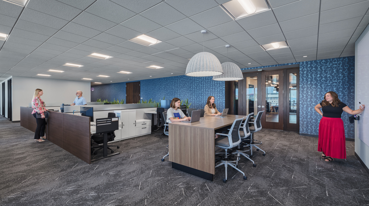 Employees collaborate at a station near their desks