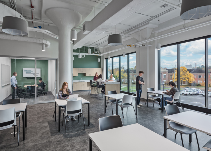 Students work in small groups or independently in a collaboration area with tables