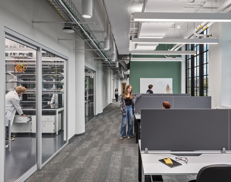 Labs are visible on the left through glass panels and workstations are available on the right