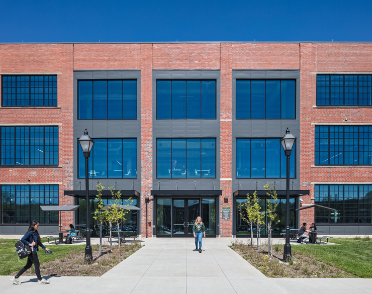 An exterior shot of the building shows a student exiting the building