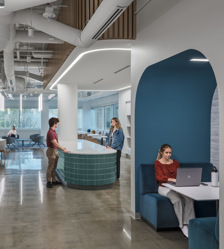 Two employees talk over an island in the office kitchen