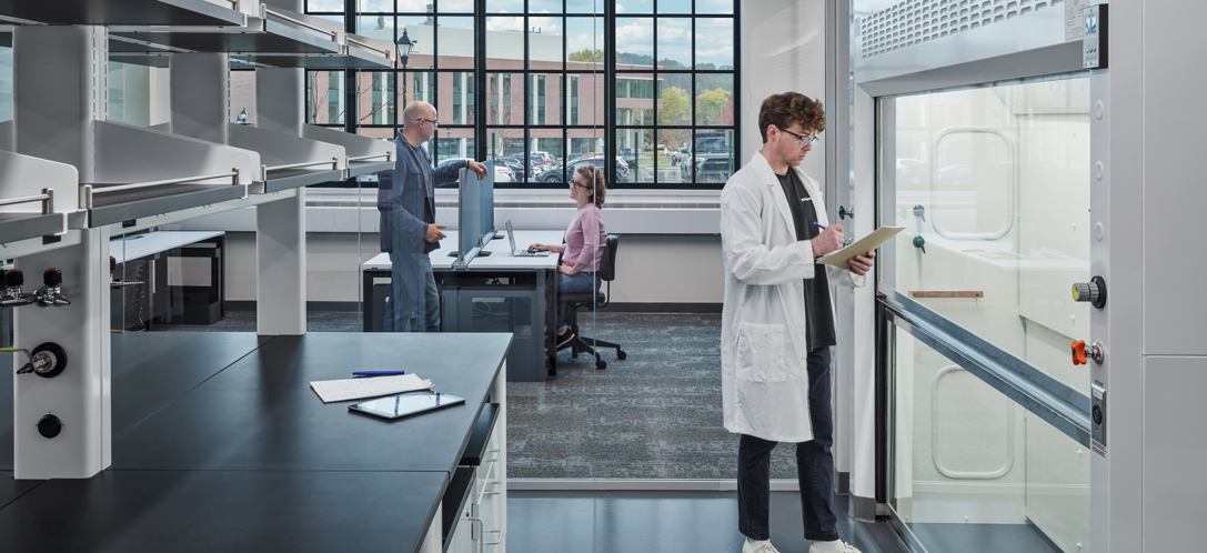 Lab bench space with adjacent glass-enclosed space for meeting.