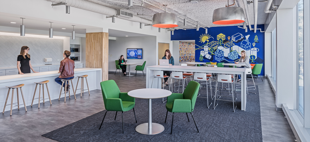 Employees gather in an employee break area with a kitchen