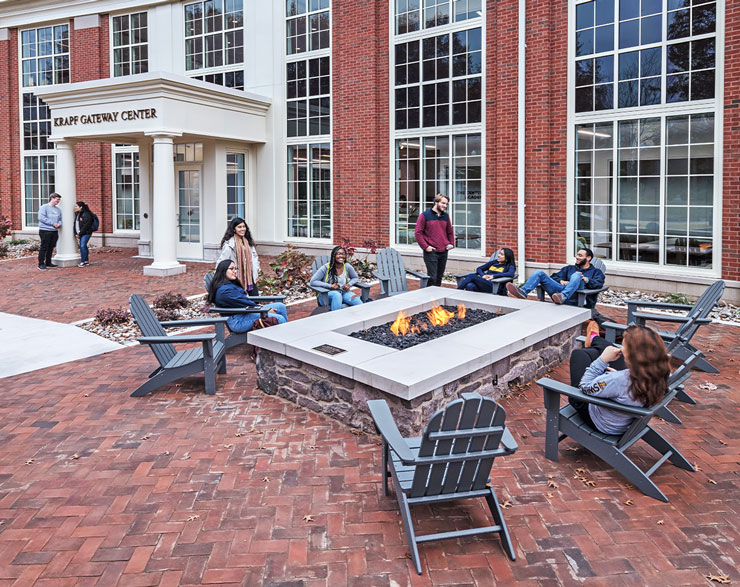 Students gather around a firepit 