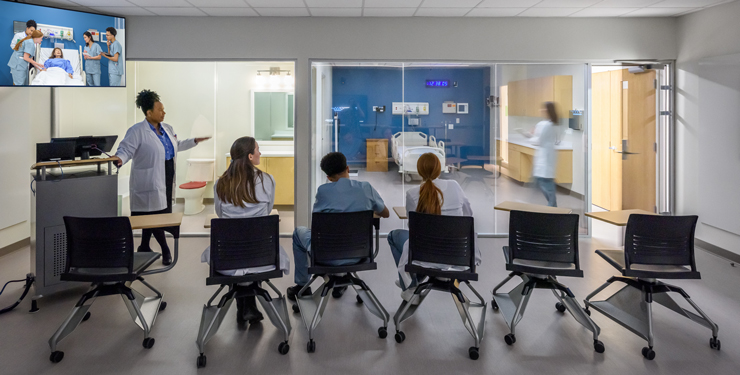 Students watch what is happening inside the simulation room