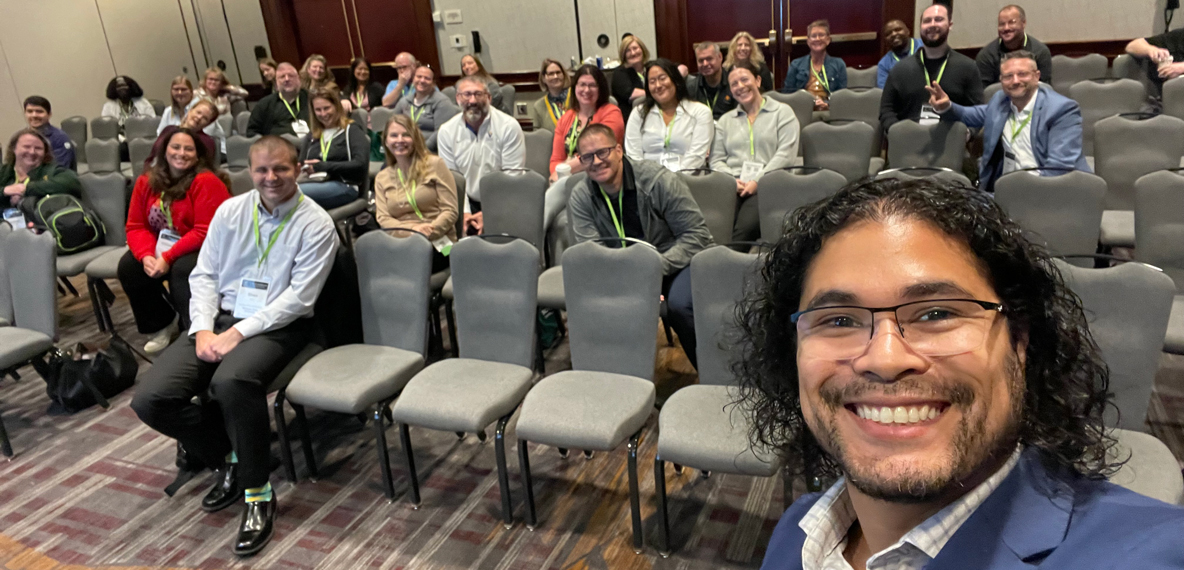 Alejandro Medina snaps a selfie in front of the attendees for his speaking session