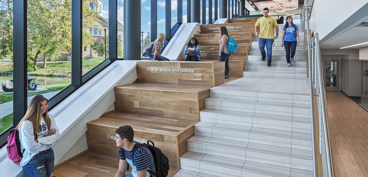 Students gather on a staircase inside University of St. Francis Achatz Hall