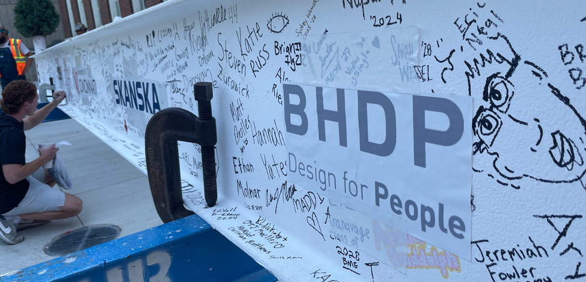 A beam with BHDP's logo surrounded by signatures